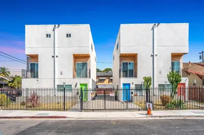 a white building with a fence in front of it at Upscale 4BR Townhouse Sleeps 8 with Fast WiFi in Los Angeles