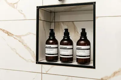 three bottles of alcohol on a shelf in a bathroom at Hollywood Celebrity 2 Bd with SkyLine and Hollywood Sing View in Los Angeles