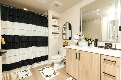 a bathroom with a black and white shower curtain and a toilet at Hollywood Celebrity 2 Bd with SkyLine and Hollywood Sing View in Los Angeles