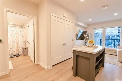 an empty living room with a white door and a table at Hollywood Palladium 1 BD EV charger Free Parking in Los Angeles