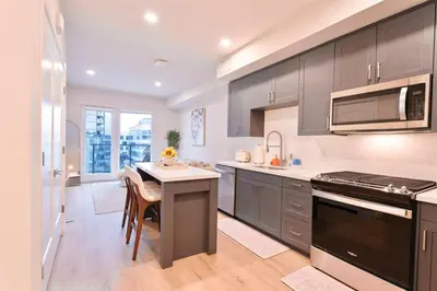a kitchen with gray cabinets and a table with chairs at Hollywood Palladium 1 BD EV charger Free Parking in Los Angeles