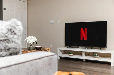 a living room with a tv on a white entertainment center at Stylish Glendale Retreat by Americana & Galleria in Glendale