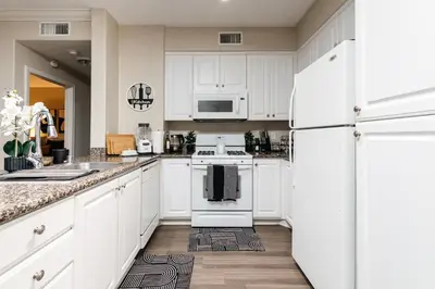 a kitchen with white cabinets and a white refrigerator at Stylish Glendale Retreat by Americana & Galleria in Glendale
