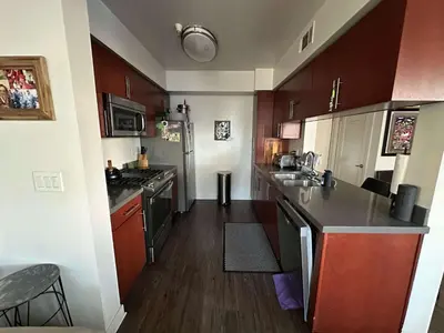 a small kitchen with wooden cabinets and a counter top at Walk to Beach & Promenade Cozy Santa Monica Condo in Los Angeles