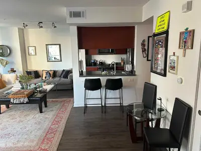 a kitchen and a living room with a table and chairs at Walk to Beach & Promenade Cozy Santa Monica Condo in Los Angeles