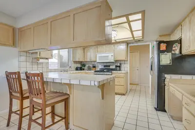 a kitchen with a counter and two chairs in it at Golf, Fish and More! Peaceful Home in Helendale in Helendale