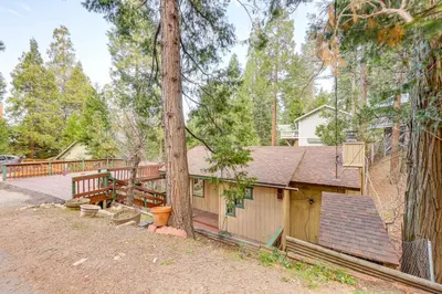 a house with a deck and a tree at 1 Mi to Lake Gregory! Updated Family Home with Deck in Crestline