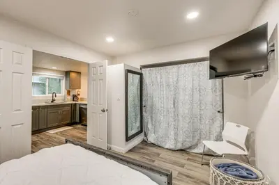 a bedroom with a bed and a chair and a kitchen at 1 Mi to Lake Gregory! Updated Family Home with Deck in Crestline