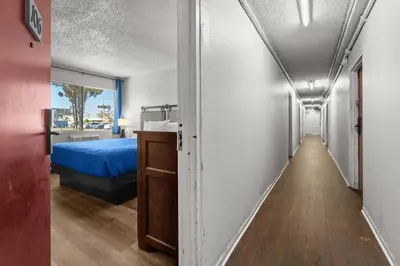 a corridor of a room with a bed and a door at Studio Lodge Hotel in Hewitt