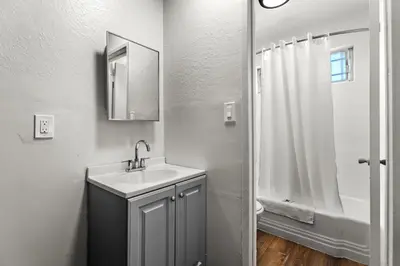 a white bathroom with a sink and a shower at Studio Lodge Hotel in Hewitt