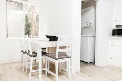 a white kitchen with a white table and chairs at Peaceful 2BD Home in WeHo in Los Angeles