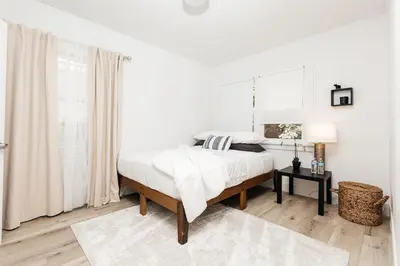 a white bedroom with a bed and a table at Peaceful 2BD Home in WeHo in Los Angeles