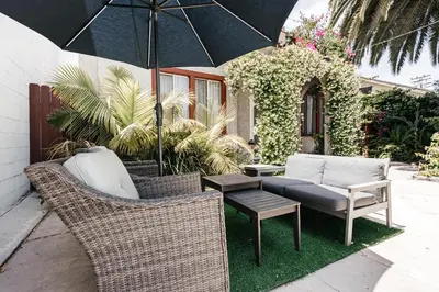 a patio with two chairs and a table with an umbrella at Peaceful 2BD Home in WeHo in Los Angeles