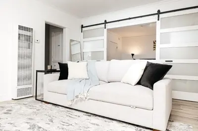 a white living room with a white couch and a mirror at Peaceful 2BD Home in WeHo in Los Angeles