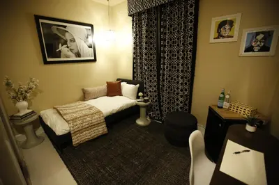 a small bedroom with a bed and a couch at The Crescent Hotel Beverly Hills in Los Angeles