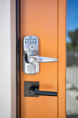 an orange door with a silver door knob and a door handle at 2BR 2BA Villa in Melrose with Free Parking in Los Angeles