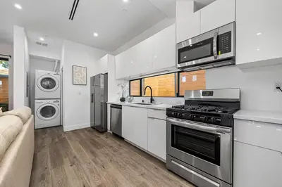 a white kitchen with a stove and a microwave at 7 BR double house with parking and a backyard in LA in Los Angeles