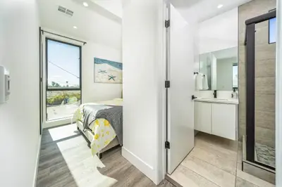 a bedroom with a bed and a bathroom with a window at 7 BR double house with parking and a backyard in LA in Los Angeles
