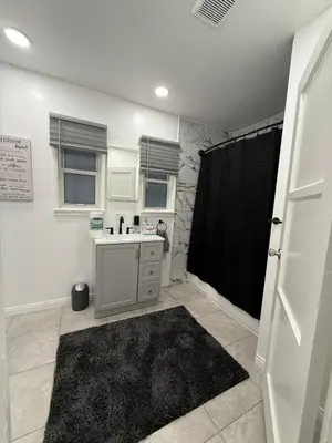 a bathroom with a sink and a black shower curtain at Modern2BR Home SoFi LAX Parking Fast WiFi in Los Angeles