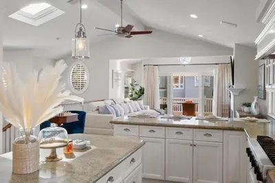 a kitchen with white cabinets and a living room at 4br Beach House Steps from Beach with AC Parking BBQ in Hermosa Beach