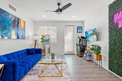 a living room with a blue couch and a table at Charming 3BR Apartment | Near Disney + Arcade in Placentia