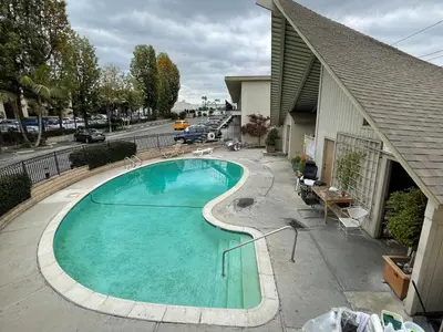 a swimming pool on the side of a house at Akua Inn & Suites - Anaheim - Fullerton in Anaheim
