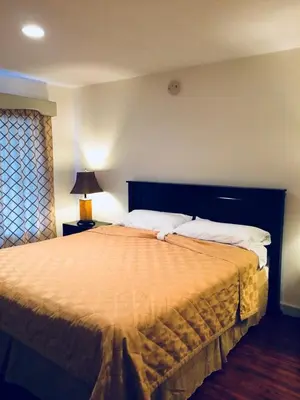 a bedroom with a large bed with white pillows at Akua Inn & Suites - Anaheim - Fullerton in Anaheim