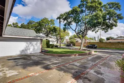 a driveway of a house with a white garage at 5 Mi to Anaheim Convention Center Retreat with Yard in Anaheim