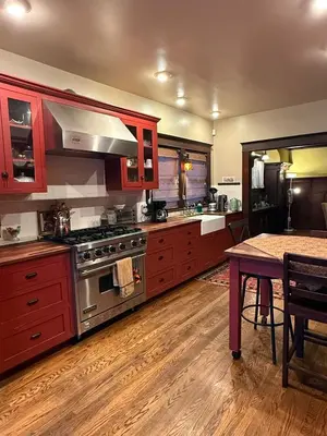 a kitchen with red cabinets and a stainless steel stove at Family gateway in the heart of Los Angeles 2bedroom 2bath backyard in Los Angeles