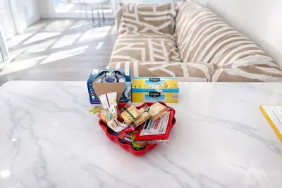 a basket of food on a table next to a couch at Brand new private Home with Yard free parking, near Ontario airport in Ontario