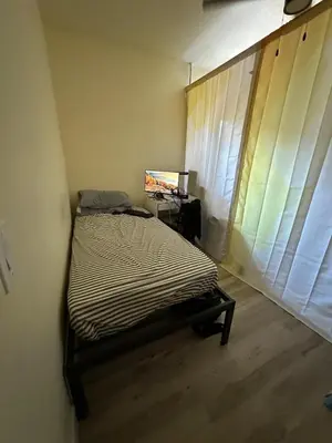 a bedroom with a bed and a desk with a laptop at Shared but isolated room in Central Los Angeles in Los Angeles