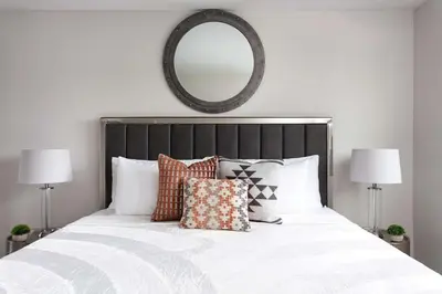 a bedroom with a large bed with pillows and a mirror at Relax in Spacious 4BR Home Sleeps 8 with Parking in North Hollywood