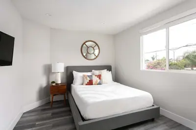 a white bedroom with a bed and a window at Relax in Spacious 4BR Home Sleeps 8 with Parking in North Hollywood
