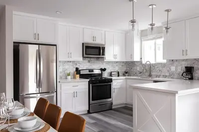 a kitchen with white cabinets and stainless steel appliances at Relax in Spacious 4BR Home Sleeps 8 with Parking in North Hollywood