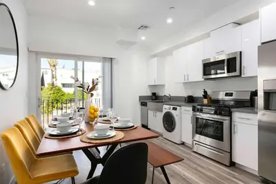 a white kitchen with a table and chairs at Spacious 4BR Townhouse with Free Parking Near DTLA in Los Angeles