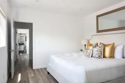 a white bedroom with a large white bed with pillows at Spacious 4BR Townhouse with Free Parking Near DTLA in Los Angeles