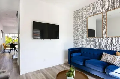 a living room with a blue couch and a tv at Spacious 4BR Townhouse with Free Parking Near DTLA in Los Angeles