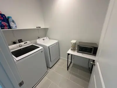 a small kitchen with a washer and dryer at Ali's home in Fontana