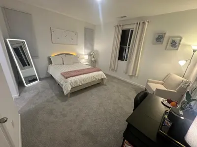 a bedroom with a bed and a couch and a mirror at Ali's home in Fontana
