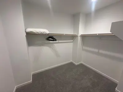 an empty closet with white walls and a towel at Ali's home in Fontana