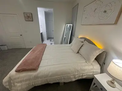 a bedroom with a large bed with white sheets and pillows at Ali's home in Fontana