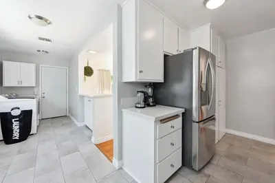 a kitchen with white cabinets and a stainless steel refrigerator at Heated Pool Oasis Close to Attractions in Encino
