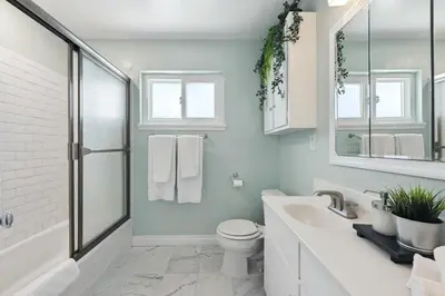 a white bathroom with a toilet and a sink at Heated Pool Oasis Close to Attractions in Encino
