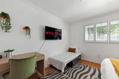 a white room with a desk and a table and a couch at Heated Pool Oasis Close to Attractions in Encino