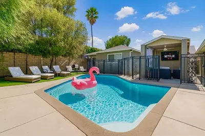 a pink swan in a swimming pool in a yard at Modern Tarzana Poolside Retreat in Tarzana