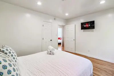 a bedroom with a bed and a tv on the wall at Modern Tarzana Poolside Retreat in Tarzana