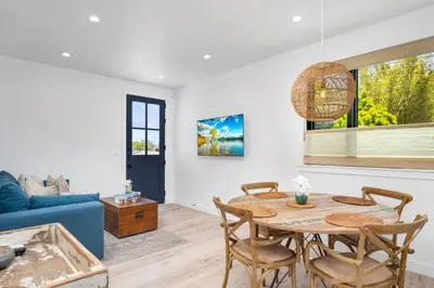a living room with a table and a blue couch at NEW Venice Rose Ave Retreat with Sunset Deck in Los Angeles