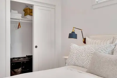 a white bedroom with a bed and a blue lamp at NEW Venice Rose Ave Retreat with Sunset Deck in Los Angeles