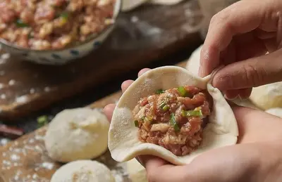 a person holding a burrito with meat in it at YouPeng Seafood and GO Believe