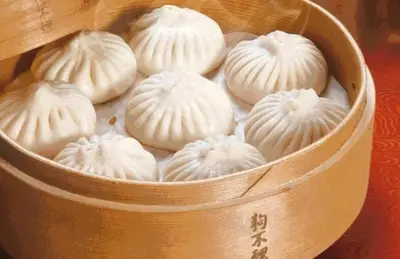 a wooden container filled with white frosted donuts at YouPeng Seafood and GO Believe